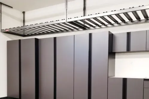 Gray storage cabinets with an overhead storage rack above a flake-coated floor.