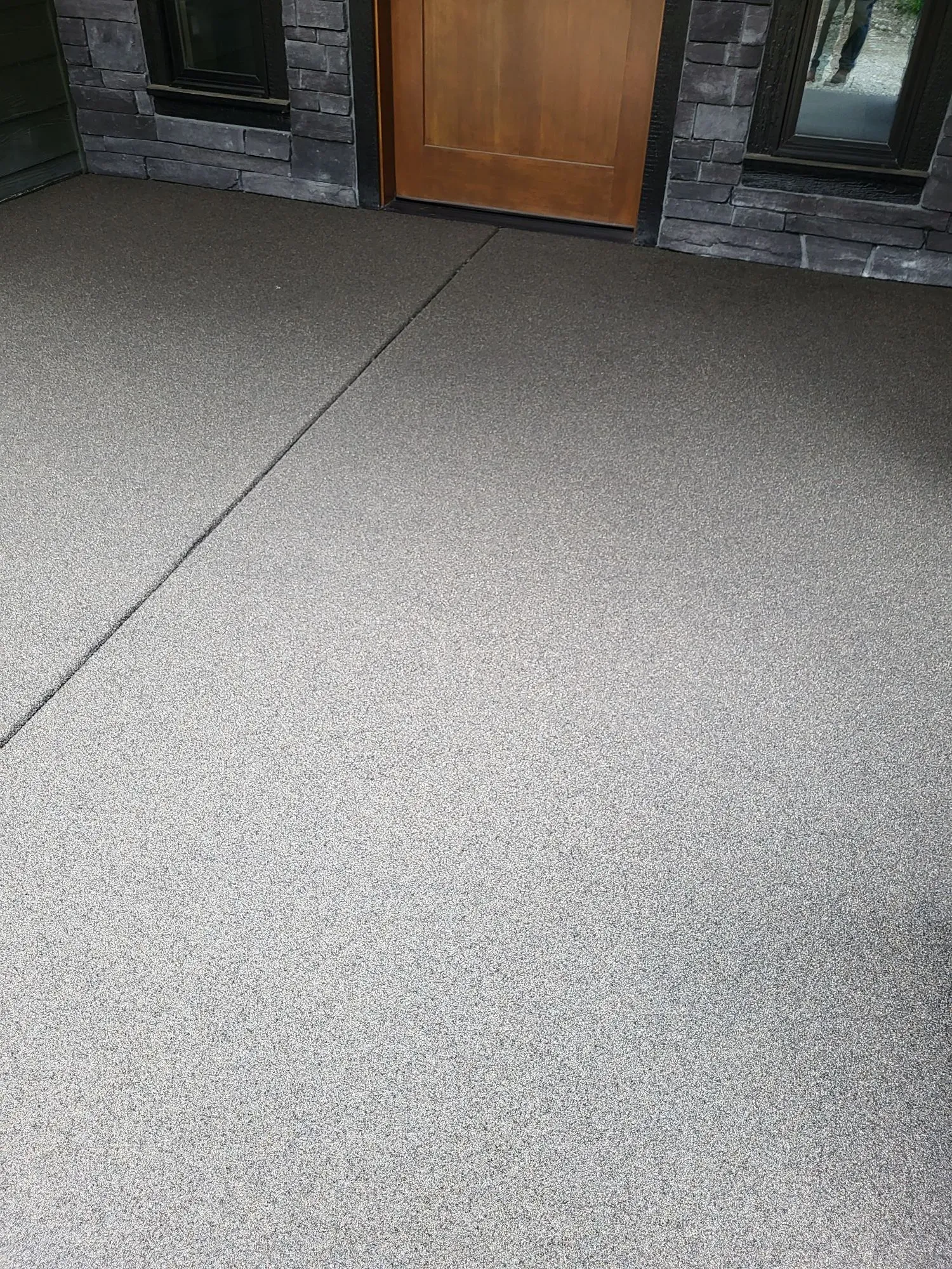 Covered residential porch finished with a decorative concrete overlay.