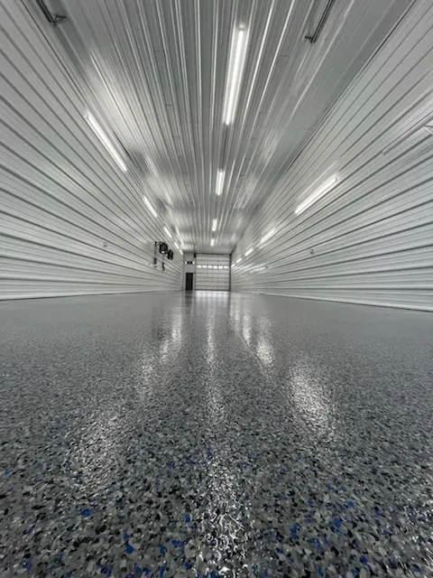 Shop interior with a black Nightfall flake floor coating and blue accent lighting.